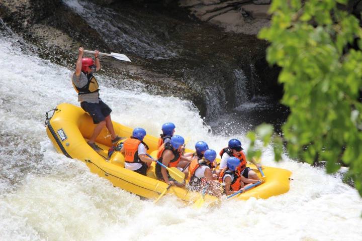 a group of people riding skis on a raft in the water