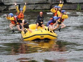 a group of people riding on the back of a boat in the water