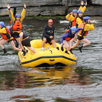a group of people riding on the back of a boat in the water