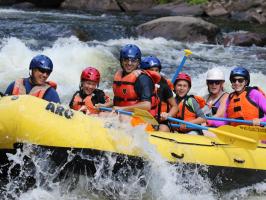 a group of people riding on a raft in the water