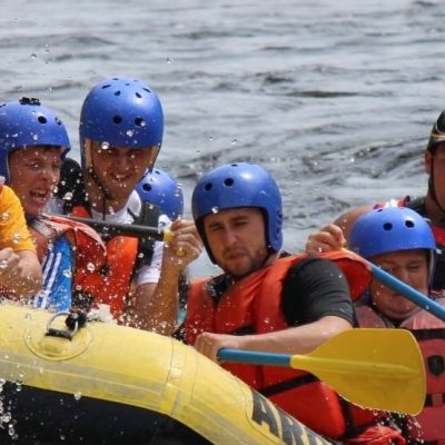 a group of people riding on the back of a boat in the water