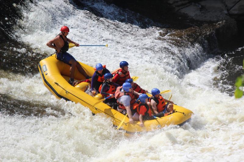 a group of people riding on the back of a boat in the water