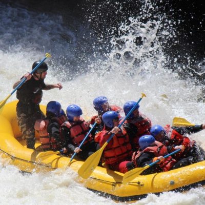 a group of people riding on the back of a boat in the water