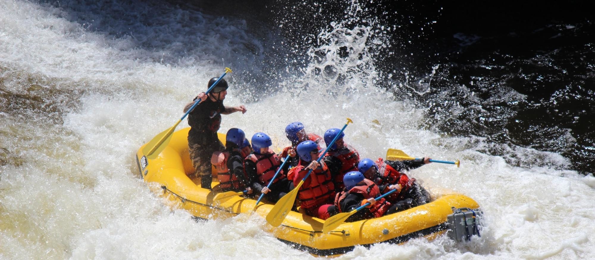 adirondack-river-outfitters-7 a group of people riding on the back of a boat in the water