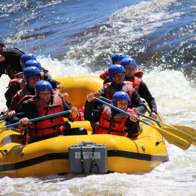 a group of people riding on the back of a boat in the water