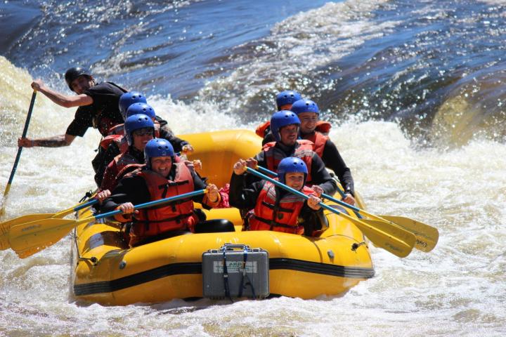 a group of people riding on the back of a boat in the water